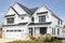 A white modern farmhouse with a black roof.