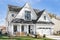 A white modern farmhouse with a black roof.