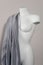 White modern mannequin or dressmakers dummy with gray fabric and hanging measuring tape