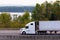 White modern semi truck with reefer on highway along river Columbia