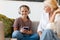 White mother and daughter using cellphone and headphones at home