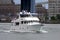 White motor yacht underway down the East River on background of the Manhattan Bridge pylon on Brooklyn side, New York