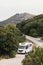 White motorhome traveling along a road through a forest