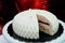 White mousse cake with a slit. Small white wedding cake on a red background