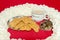 White mug with cappuchino and hungry hamster eating cookie on red background