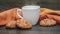 White mug with hot tea and oatmeal cookies with seeds on wooden background_