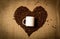 White mug in middle of heart made of coffee beans