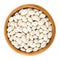 White navy beans in wooden bowl over white