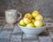 White nectarines in a deep plate on a wooden table simple rustic room