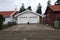 White new garage for two cars and wooden barn on private house yard