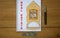 White note with inscription `real estate` on beautiful wooden table, metalic pen, coins and miniature wooden house. Business