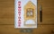 White note with inscription `remortgage` on beautiful wooden table, metalic pen, coins and miniature wooden house. Business