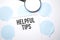 White noteapad and magnifier on blue speech bubles. Text Helpful tips. Business concept