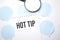 White noteapad and magnifier on blue speech bubles. Text Hot tip . Business concept