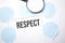 White noteapad and magnifier on blue speech bubles. Text respect. Business concept