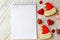 White notebook for Christmas wishes, goals, recipes for the New Year 2021 among gingerbread cookies in form of Santa Claus hat,