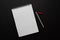 white notebook and red pencil on black background, isolated. taking note. blank paper. new year\\\'s resolution, goals. 2021. copy