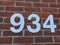 White Numbers on a Brick Wall