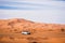 White offroad car driving in the sahara of merzouga morocco. High sand dunes in the background. Desert driving. Exploring offroad.