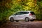 White Opel Zafira family car in autumn in the forest