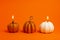 White and orange lighted decorative pumpkin candles on orange background