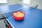 White and orange ping pong ball on ping pong table