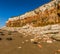 White and orange rockfalls litter the beach at the foot of the white, red and orange stratified cliffs at Old Hunstanton, Norfolk