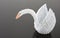 White origami swan on grey surface