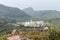 White pagoda style Jain Temples surrounded by Parasnath Hill Range, trees, and jungles in forested area. Scenic Landscape View of