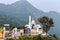 White pagoda style Jain Temples surrounded by Parasnath Hill Range, trees, and jungles in forested area. Scenic Landscape View of