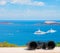 White paid telescope stands on sea coast over blue sky background