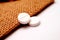 white painkiller pills on a small jute bag background