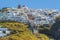 The white-painted buildings of the village of Imerovigli tumble down the cliffside of Santorini`s caldera