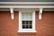 white painted dentil molding on the exterior of a dark brick georgian home