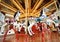 White painted horses in a carousel decorated with lights and gold