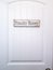 White panelled door with rustic rectangular wooden Powder Room sign