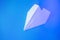 White paper airplane on a blue background.