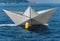 White paper boat runs fast over the blue sea with wake and buoy