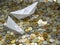 White paper boats in sea made from coins: sailing and sinking.