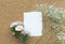 White paper card with flower on wooden corkboard