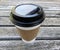 White paper coffee cup with black travel lid and corrugated fiber sleeve