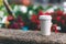 White paper cup with coffee on the street on a background of blurry colors.