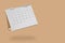 White paper desk calendar flipping page isolated on brown background