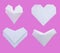 White paper folded into various heart shapes isolated on pink background.