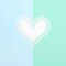 White paper heart on blue and turquoise pastel background