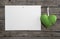 White paper on an old wooden wall with a lime green hanging hear