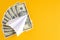White paper plane and money on yellow background composition