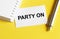 White paper with text Party On on a yellow background with stationery