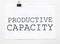 White paper with text Productive Capacity on a white background with stationery