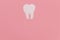 White paper tooth on a pink background. Dentistry, dentist services. copy space for text